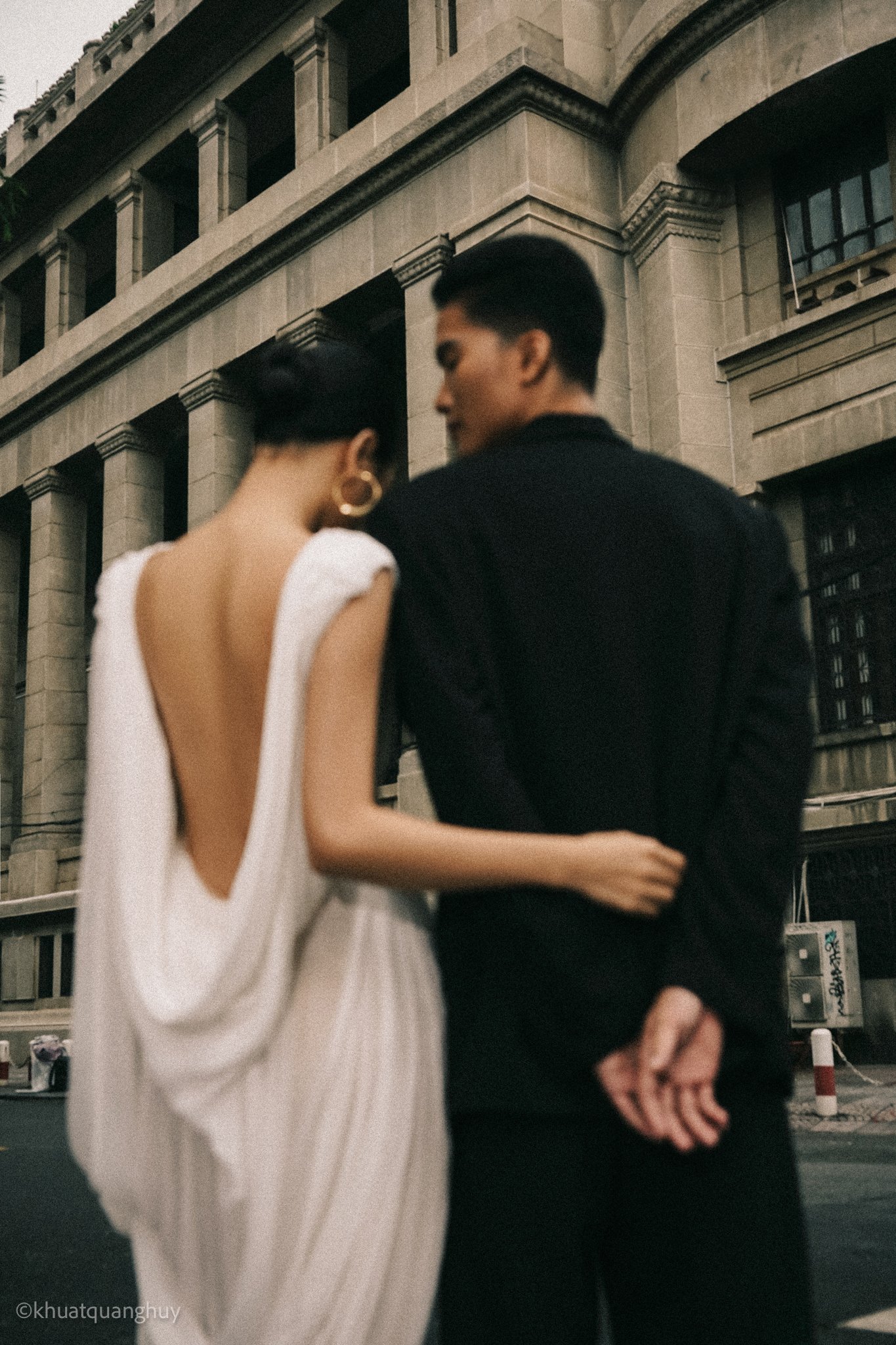 The bride Đông Phương and her groom on the street, in a backless silk dress