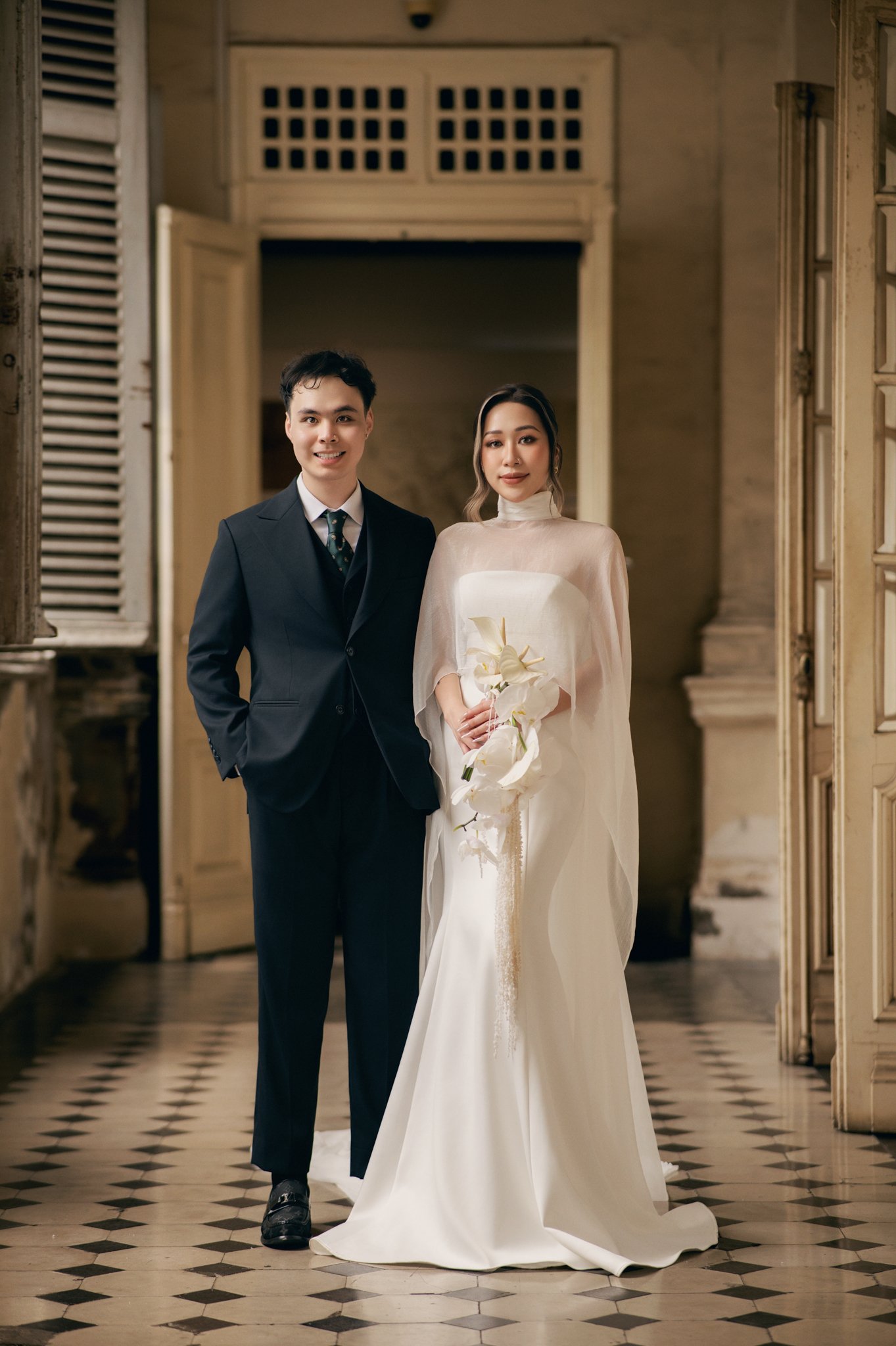Minh Anh and Hùng Vũ standing in a villa doorway