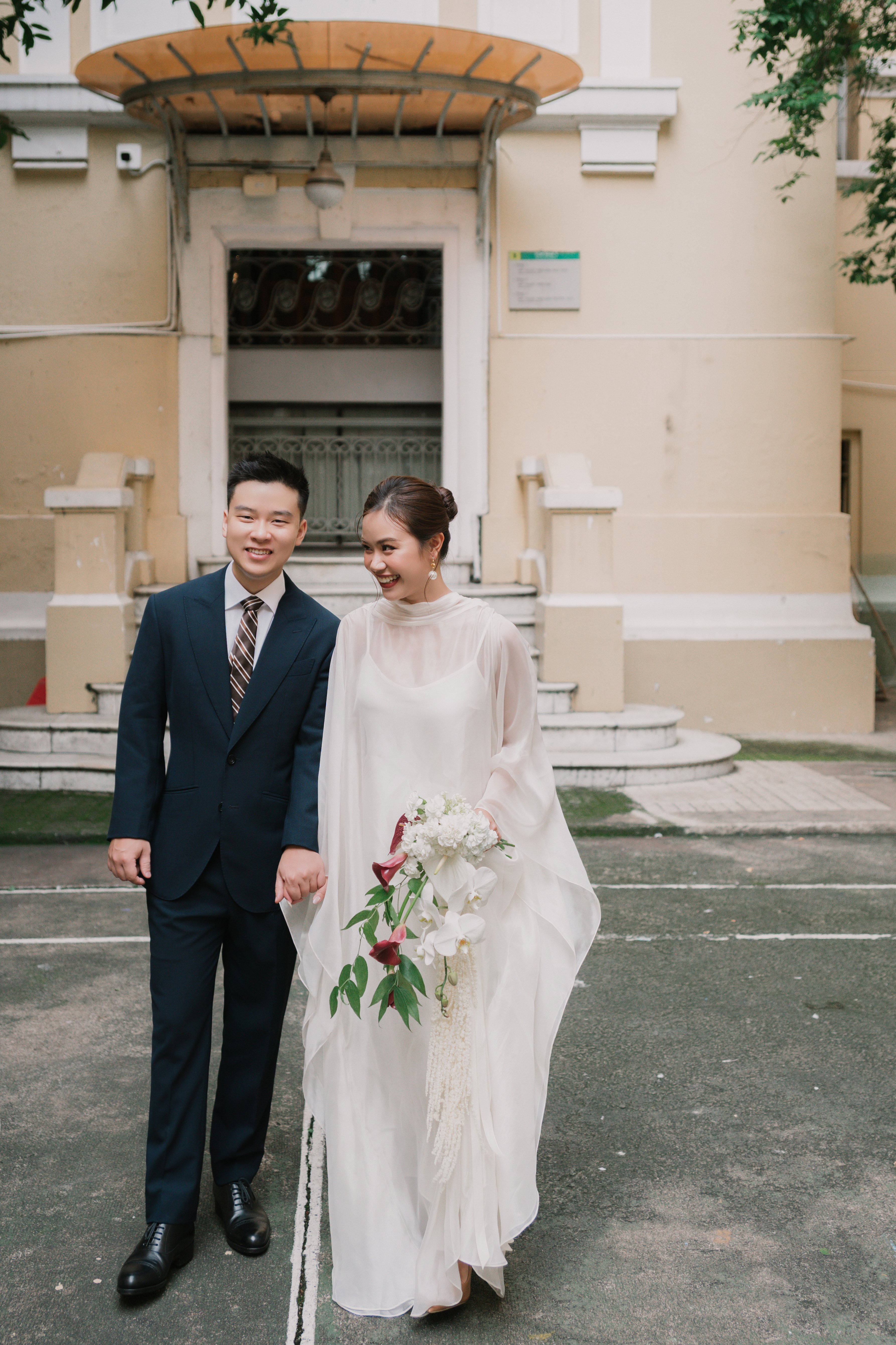 Ngọc Biết and Đức Vũ in front of a villa facade