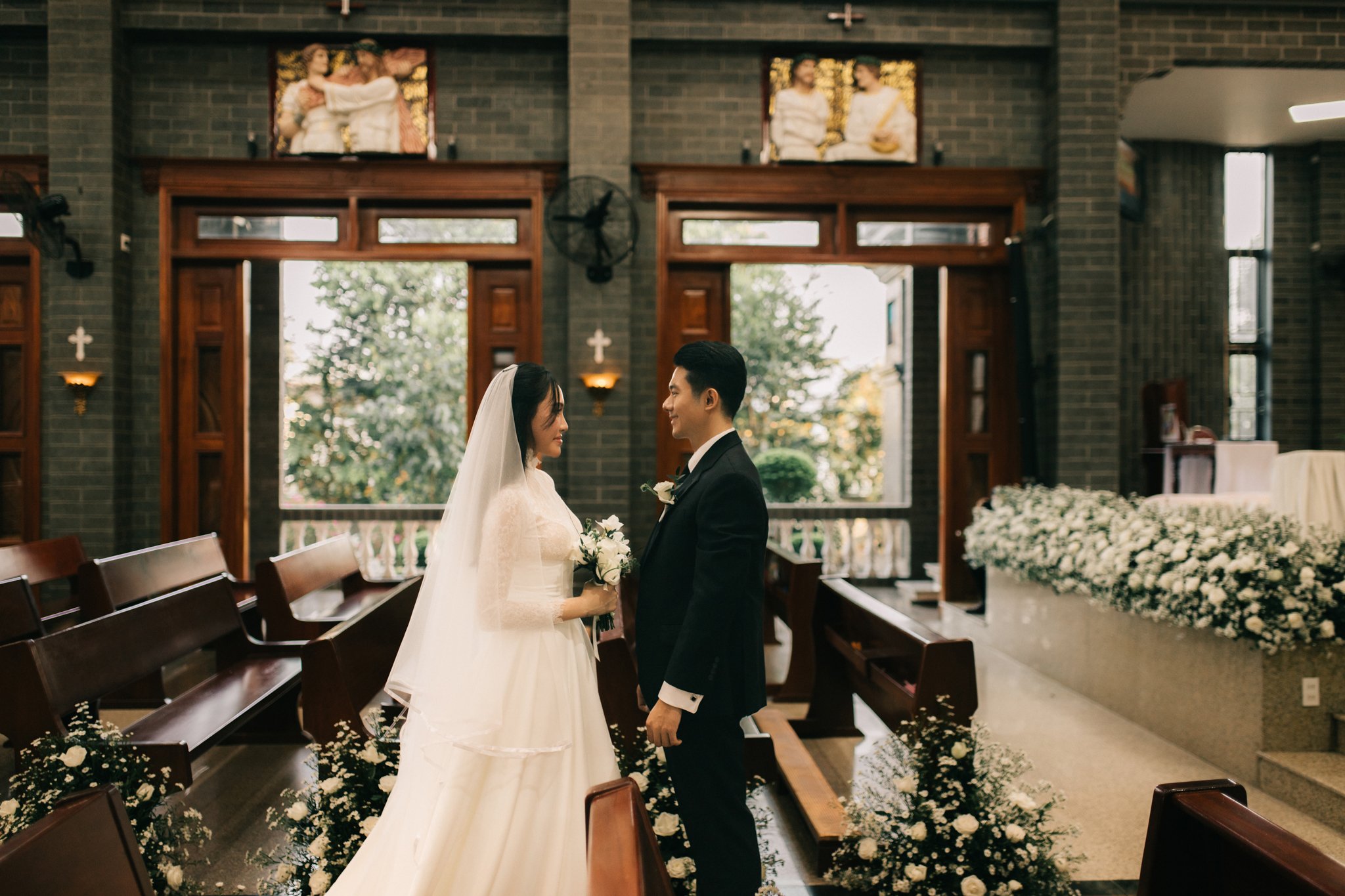 Cô dâu chú rể đứng trước bàn thờ trong lễ cưới ở nhà thờ